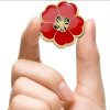 A red poppy lapel pin with intricate petal detailing, symbolizing pride. The pin can be worn on a lapel, hat, tie, or as a brooch. It represents remembrance and support, often associated with veterans.